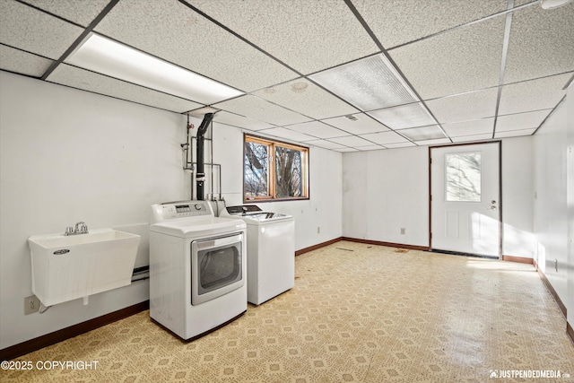 washroom featuring a wealth of natural light, laundry area, washer and dryer, and a sink