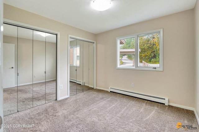 unfurnished bedroom featuring baseboards, multiple closets, baseboard heating, and carpet