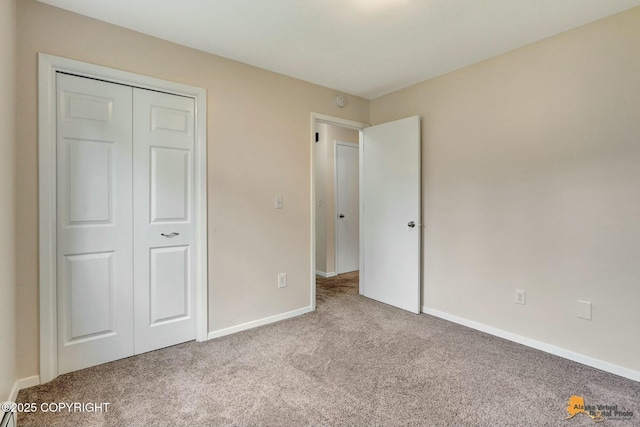 unfurnished bedroom with a closet, baseboards, and carpet flooring