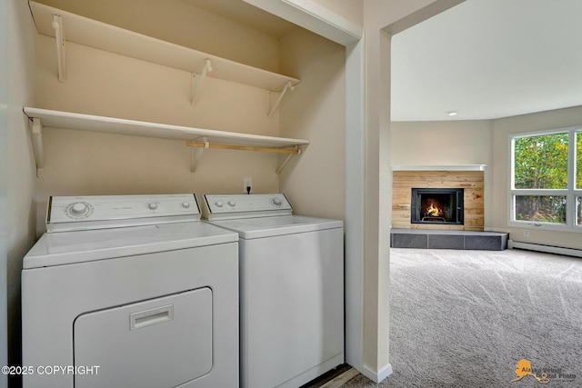 clothes washing area featuring carpet floors, laundry area, a fireplace, washer and dryer, and baseboard heating