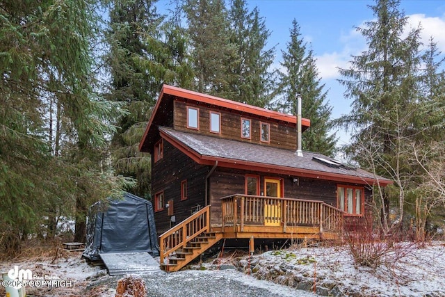 rustic home with stairway and a shingled roof