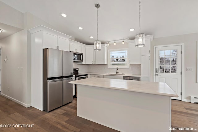 kitchen featuring a sink, tasteful backsplash, dark wood-style floors, white cabinetry, and stainless steel appliances