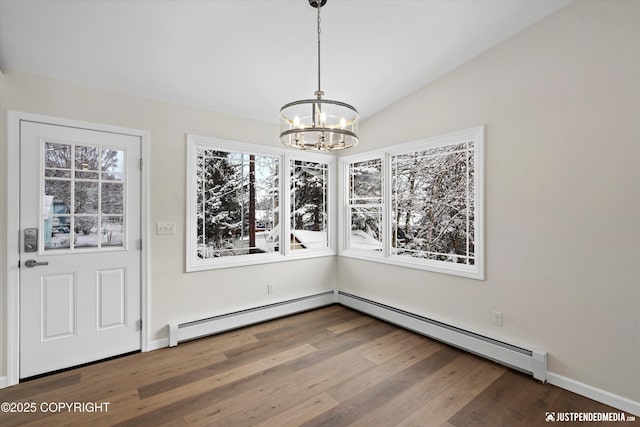 unfurnished dining area featuring vaulted ceiling, wood finished floors, an inviting chandelier, and a baseboard radiator