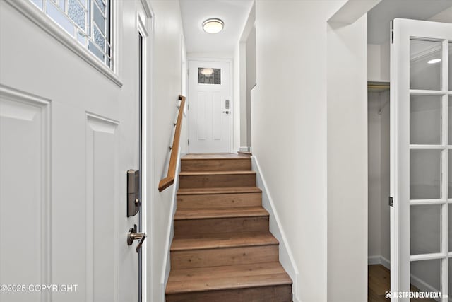 staircase featuring wood finished floors and baseboards