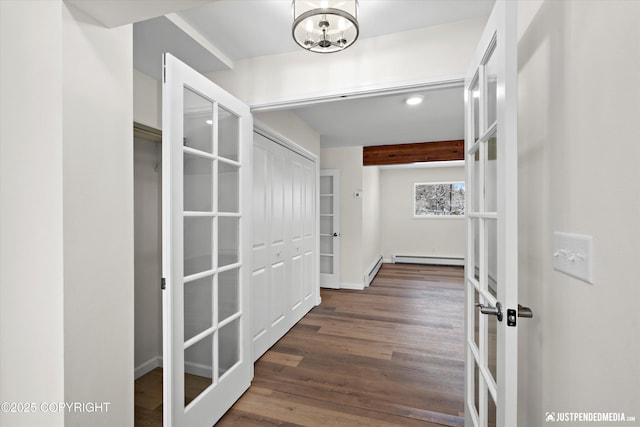 hallway with baseboards, french doors, an inviting chandelier, wood finished floors, and a baseboard radiator