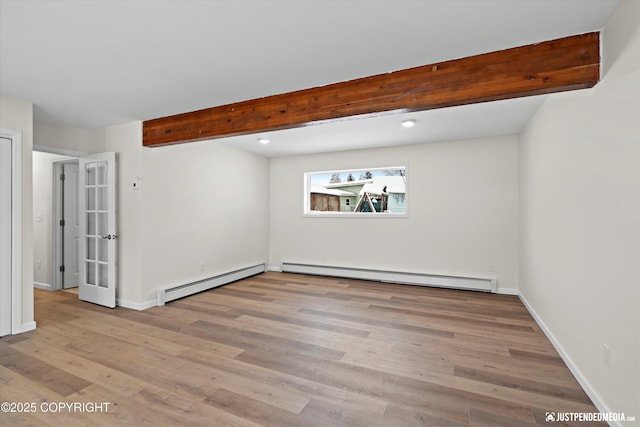 unfurnished room with beam ceiling, wood finished floors, baseboards, and a baseboard radiator