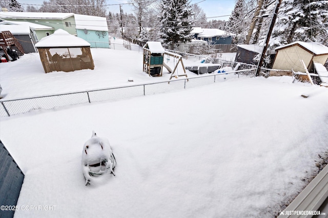 yard covered in snow with a fenced backyard