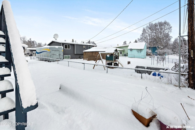 snowy yard featuring fence