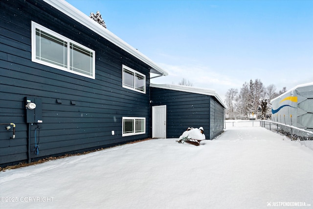 snow covered house with fence