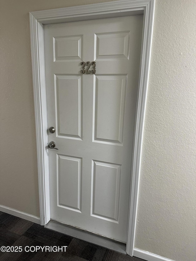 interior details with baseboards and a textured wall