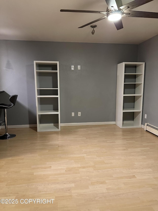 interior space with baseboards, baseboard heating, ceiling fan, and light wood finished floors