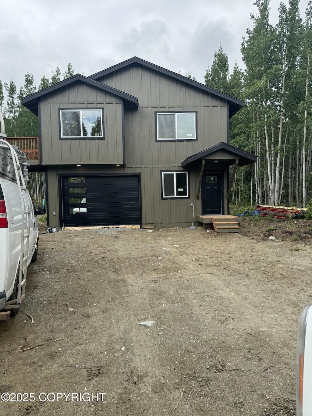 view of front of house with a garage and dirt driveway