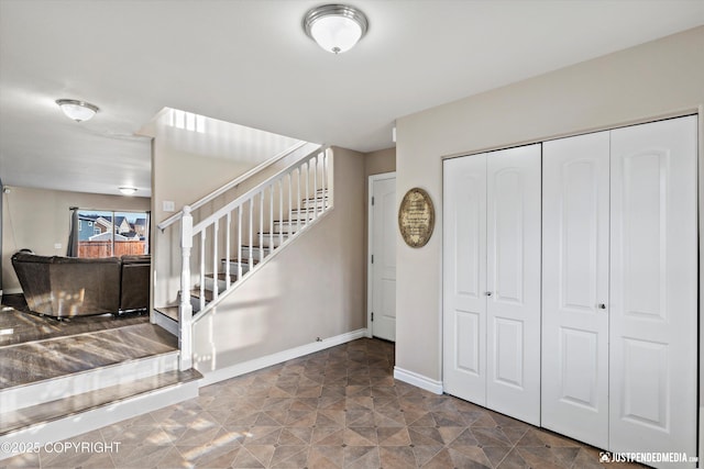 foyer entrance featuring baseboards and stairs