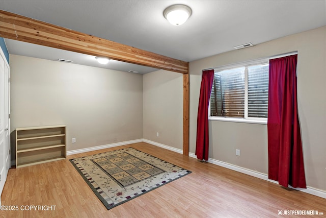 interior space featuring wood finished floors, visible vents, and baseboards