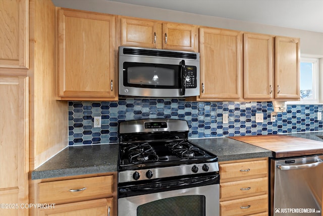 kitchen featuring stainless steel appliances, backsplash, dark countertops, and light brown cabinets