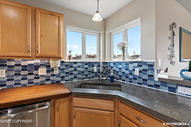 kitchen featuring tasteful backsplash, a sink, hanging light fixtures, and stainless steel dishwasher