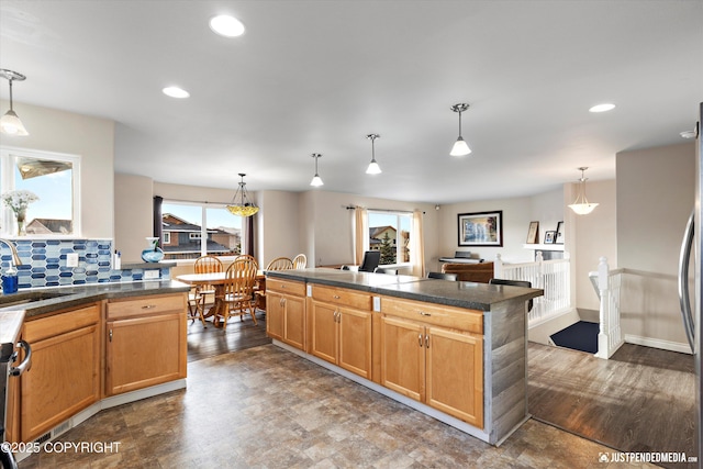 kitchen with recessed lighting, decorative backsplash, pendant lighting, and a sink