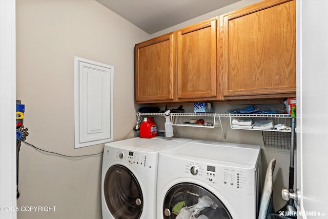 clothes washing area featuring washer and dryer and cabinet space