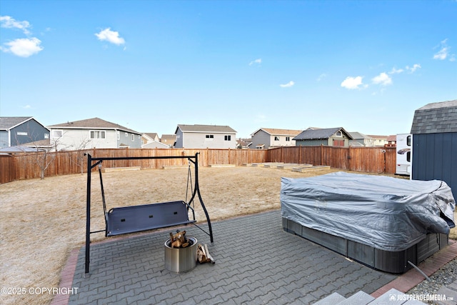 view of yard featuring an outdoor hot tub, a residential view, a patio, and a fenced backyard