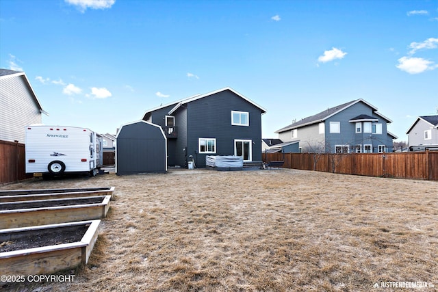 rear view of house featuring an outdoor structure, fence, and a hot tub