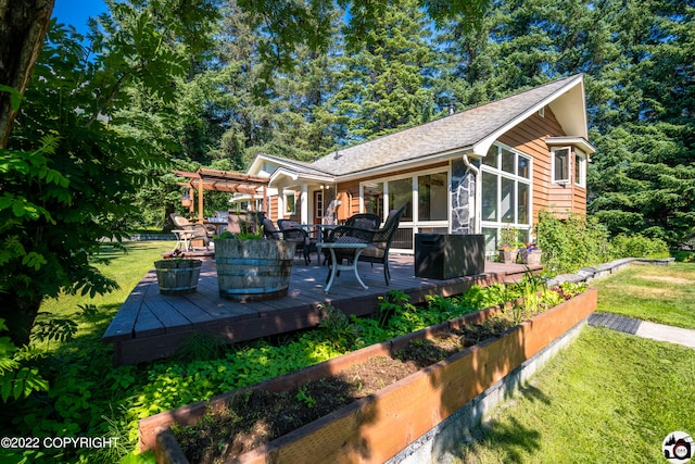 deck with outdoor dining space, a pergola, a yard, a vegetable garden, and a sunroom