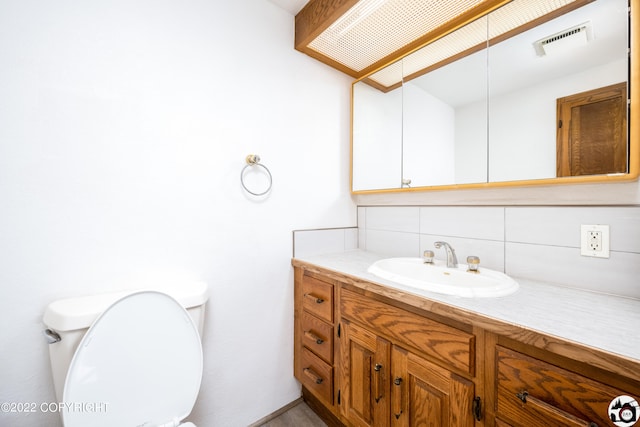 half bath featuring visible vents, backsplash, vanity, and toilet