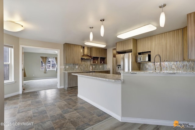1091 Northpointe Bluff Dr, Anchorage, AK 99501 - kitchen with stainless steel appliances, wall chimney exhaust hood, tasteful backsplash, a peninsula, and pendant lighting