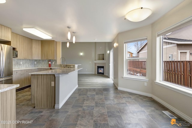 1091 Northpointe Bluff Dr, Anchorage, AK 99501 - kitchen featuring stainless steel fridge, modern cabinets, backsplash, open floor plan, and light brown cabinetry