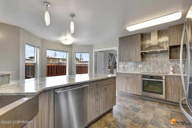 1091 Northpointe Bluff Dr, Anchorage, AK 99501 - kitchen featuring appliances with stainless steel finishes, wall chimney exhaust hood, backsplash, and modern cabinets