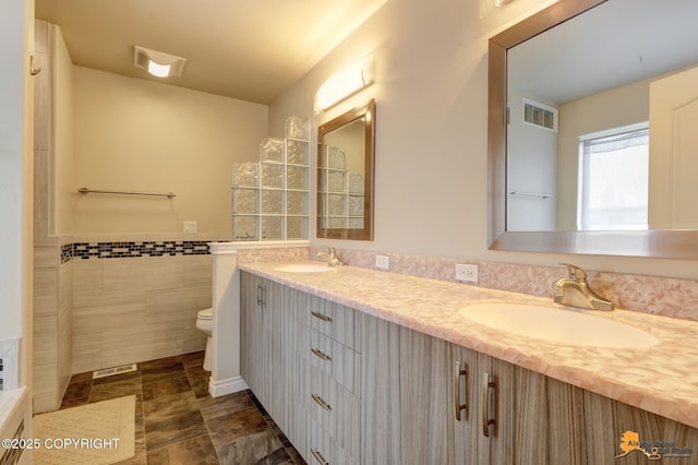 1091 Northpointe Bluff Dr, Anchorage, AK 99501 - bathroom with double vanity, tile walls, and wainscoting