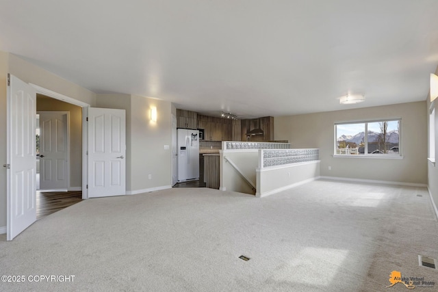 1091 Northpointe Bluff Dr, Anchorage, AK 99501 - unfurnished living room featuring light colored carpet and baseboards
