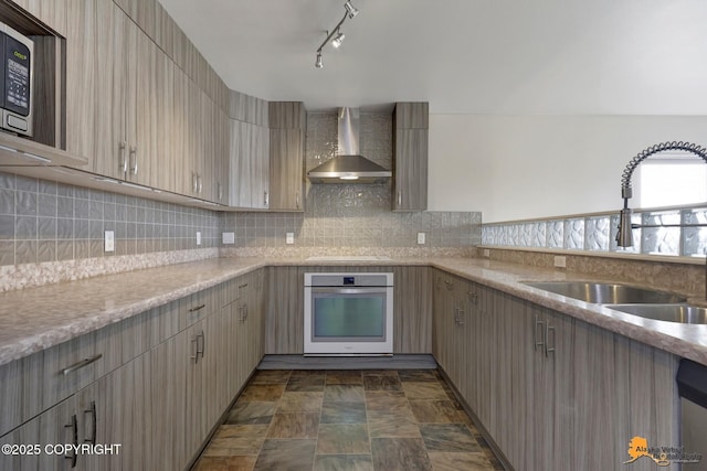 1091 Northpointe Bluff Dr, Anchorage, AK 99501 - kitchen with oven, wall chimney range hood, cooktop, stainless steel microwave, and tasteful backsplash