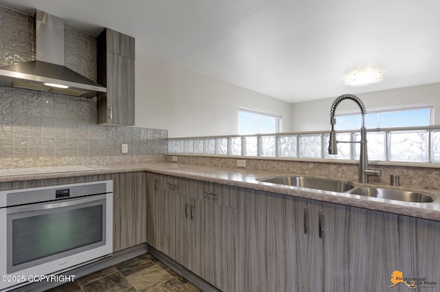 1091 Northpointe Bluff Dr, Anchorage, AK 99501 - kitchen with wall chimney exhaust hood, oven, cooktop, and light countertops