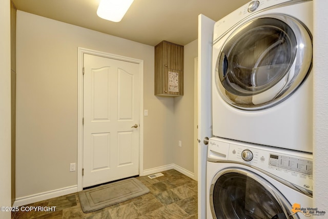 1091 Northpointe Bluff Dr, Anchorage, AK 99501 - washroom featuring stacked washer / drying machine and stone finish flooring