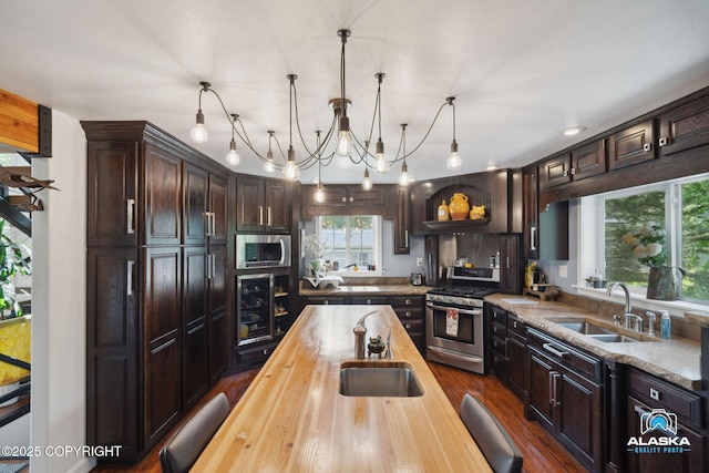 19136 S Birchwood Loop Rd, Chugiak, AK 99567 - kitchen featuring stainless steel appliances, wooden counters, a sink, and dark brown cabinets
