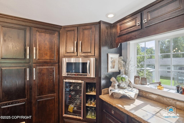 19136 S Birchwood Loop Rd, Chugiak, AK 99567 - kitchen featuring beverage cooler, stainless steel microwave, light countertops, and dark brown cabinets