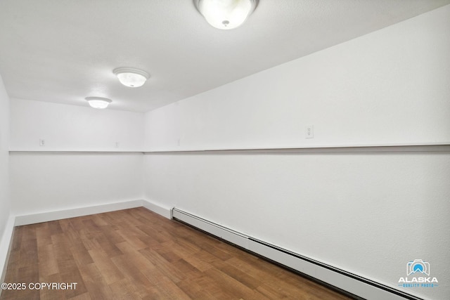 19136 S Birchwood Loop Rd, Chugiak, AK 99567 - unfurnished room featuring a baseboard radiator, wood finished floors, and baseboards