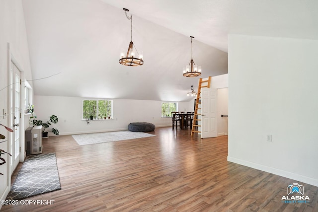 19136 S Birchwood Loop Rd, Chugiak, AK 99567 - unfurnished living room featuring a chandelier, high vaulted ceiling, wood finished floors, and baseboards