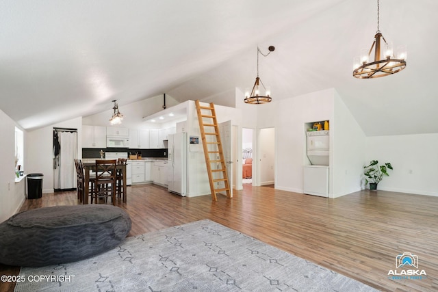 19136 S Birchwood Loop Rd, Chugiak, AK 99567 - kitchen featuring white appliances, open floor plan, a chandelier, lofted ceiling, and light wood-type flooring