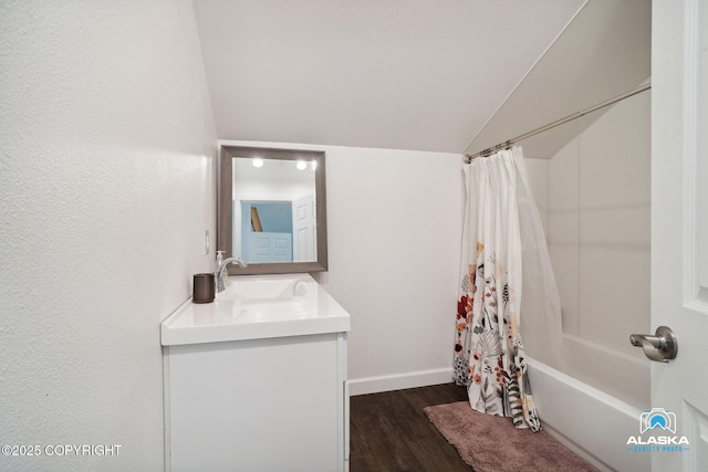 19136 S Birchwood Loop Rd, Chugiak, AK 99567 - bathroom with lofted ceiling, wood finished floors, vanity, shower / bath combo with shower curtain, and baseboards