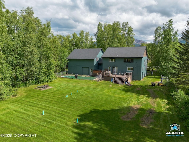 19136 S Birchwood Loop Rd, Chugiak, AK 99567 - back of house featuring a deck, a yard, and a fire pit
