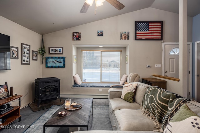 living room with a ceiling fan, a baseboard radiator, a wood stove, vaulted ceiling, and carpet flooring