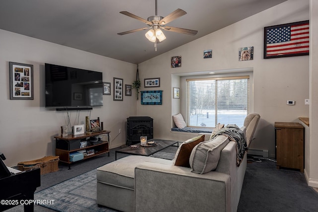 living area featuring a wood stove, ceiling fan, vaulted ceiling, baseboard heating, and dark carpet