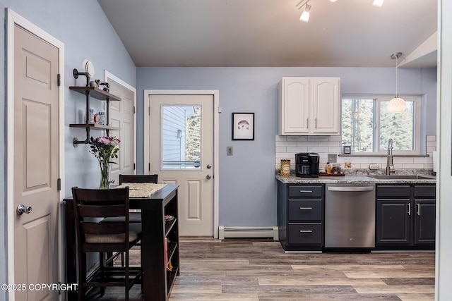 kitchen featuring a sink, tasteful backsplash, white cabinetry, baseboard heating, and dishwasher