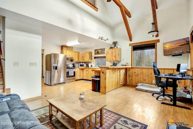 living room featuring light wood-type flooring, a high ceiling, and a wainscoted wall