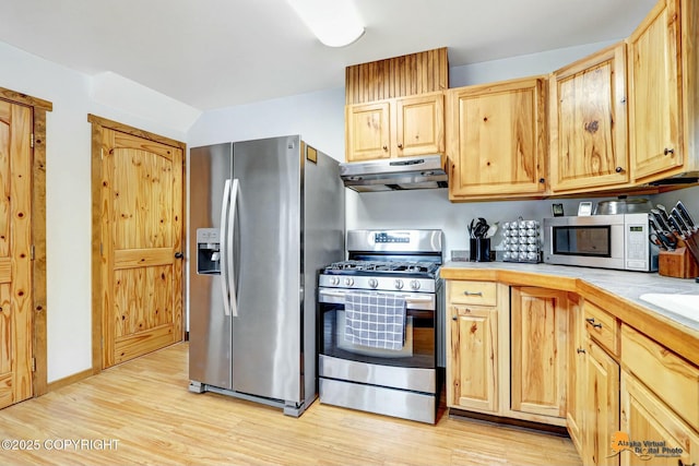 kitchen featuring light wood-style flooring, light brown cabinets, under cabinet range hood, appliances with stainless steel finishes, and light countertops