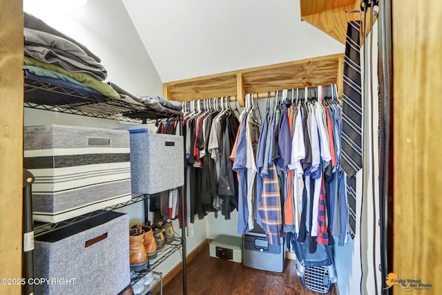 spacious closet with lofted ceiling and wood finished floors