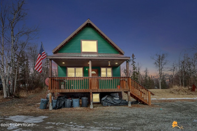 rustic home featuring metal roof, a porch, and stairs