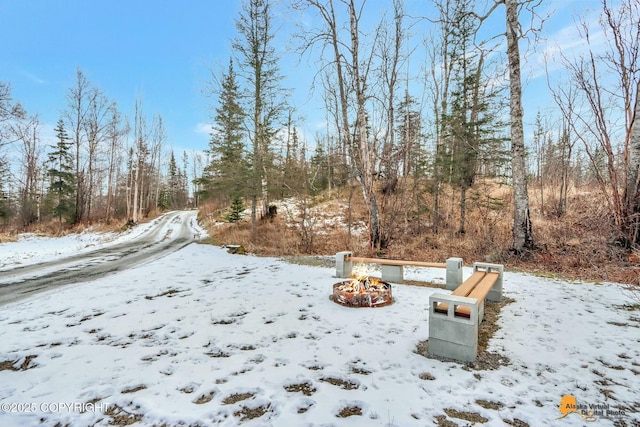 yard layered in snow with an outdoor fire pit