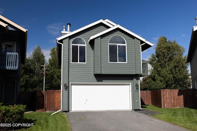 view of front of home featuring a front yard, fence, a garage, and driveway